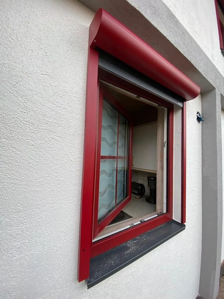 Fenster mit neuem roten Vorbaurollladen von außen