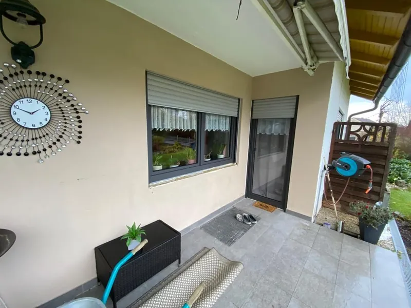 Überdachte Terrasse mit Fenster und Rollladen