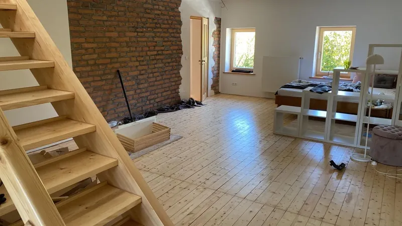 Wohnraum mit Holztreppe und neu verlegtem Dielenboden